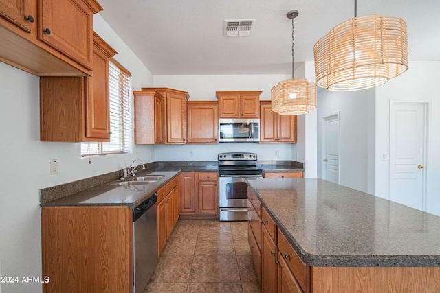 kitchen featuring stainless steel appliances, a center island, sink, and hanging light fixtures