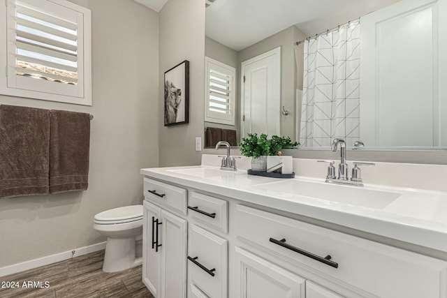 bathroom featuring vanity, hardwood / wood-style floors, curtained shower, and toilet