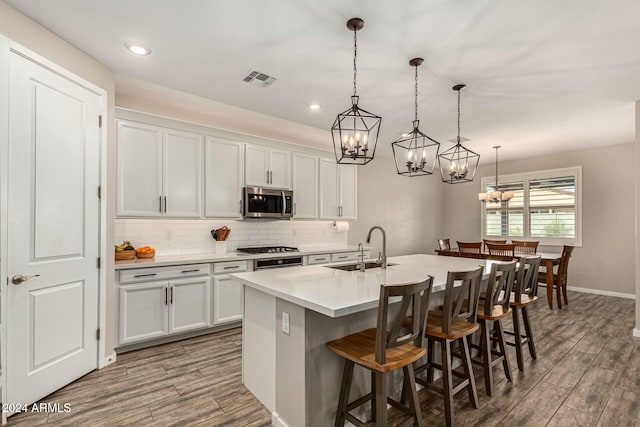 kitchen featuring white cabinetry, appliances with stainless steel finishes, sink, and pendant lighting