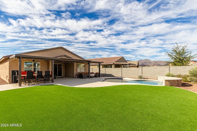 rear view of property with a yard, a fenced in pool, and a patio area