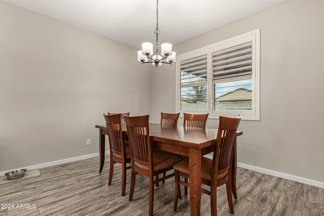 dining space featuring dark hardwood / wood-style flooring and an inviting chandelier