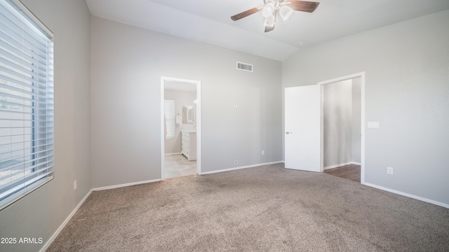 unfurnished bedroom with vaulted ceiling, carpet floors, multiple windows, and visible vents