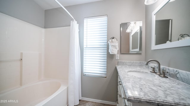 bathroom with shower / bath combo with shower curtain, vanity, and baseboards