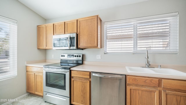 kitchen with a wealth of natural light, stainless steel appliances, a sink, and light countertops