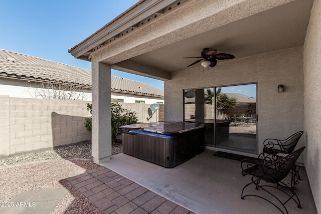 view of patio / terrace with ceiling fan and a hot tub