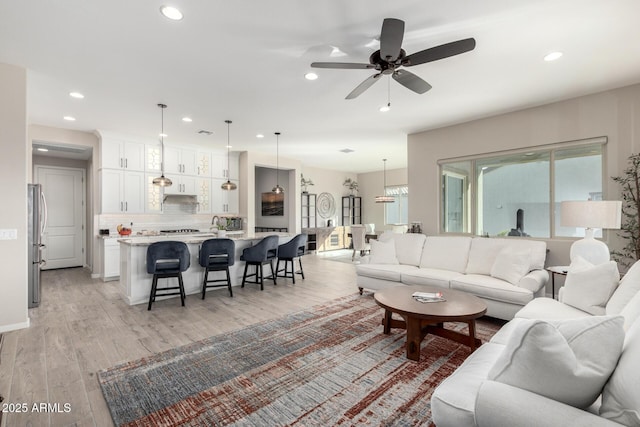 living room featuring light hardwood / wood-style floors and ceiling fan