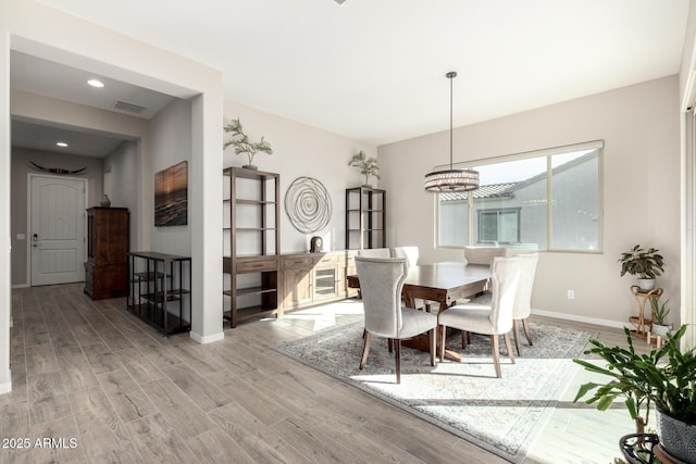 dining room featuring light hardwood / wood-style flooring and a notable chandelier