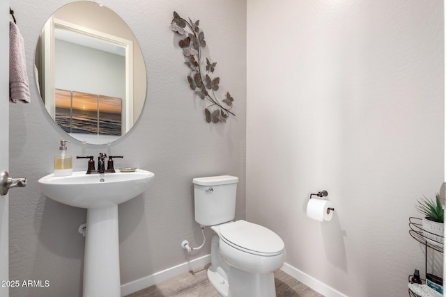 bathroom featuring hardwood / wood-style floors and toilet