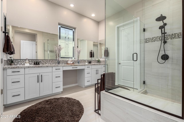 bathroom featuring vanity, an enclosed shower, and decorative backsplash