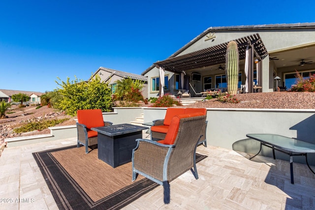 view of patio / terrace with a fire pit, ceiling fan, and a pergola