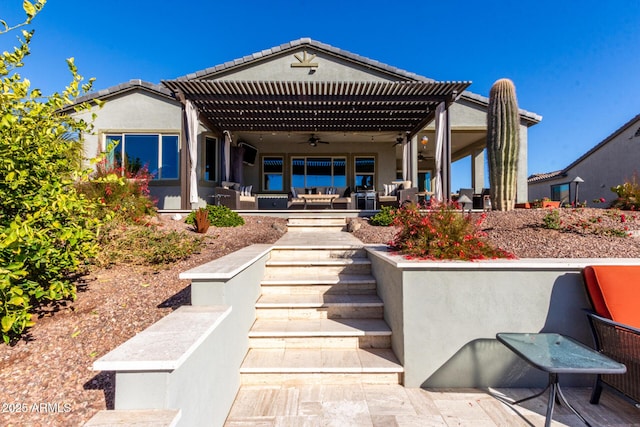 rear view of property featuring a pergola and ceiling fan