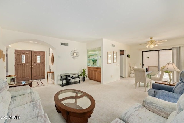 carpeted living room with ceiling fan