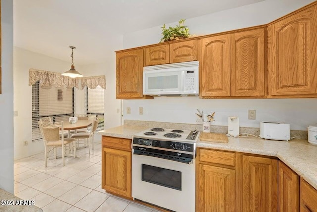 kitchen featuring light tile patterned floors, white appliances, and decorative light fixtures