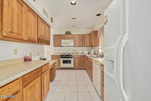 kitchen featuring sink, light tile patterned floors, and white appliances