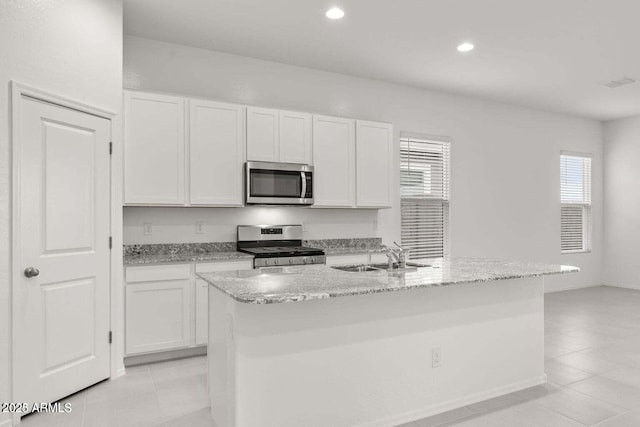 kitchen featuring an island with sink, appliances with stainless steel finishes, sink, and white cabinets