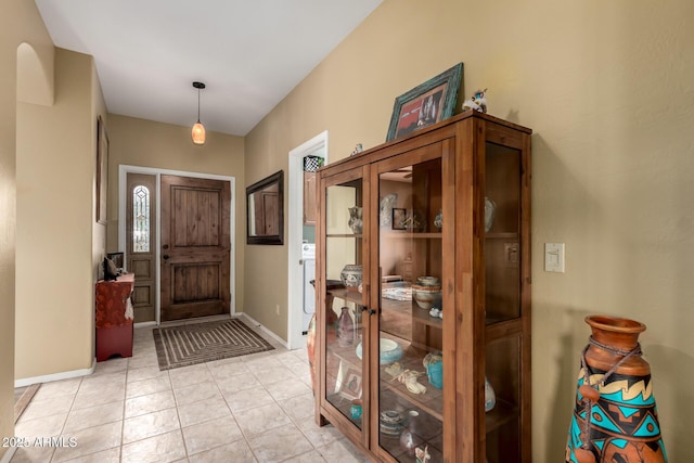 foyer entrance with baseboards and light tile patterned flooring