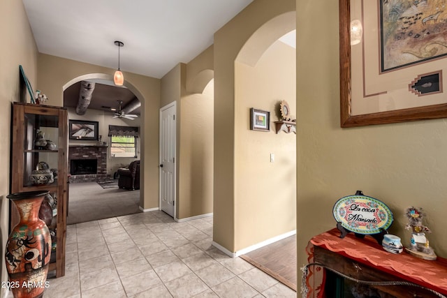 corridor featuring baseboards and arched walkways