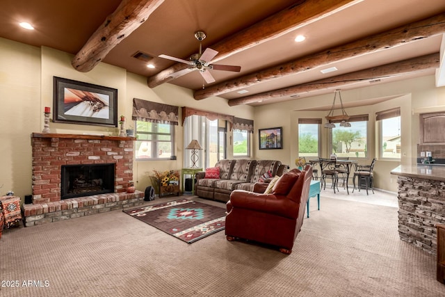 living room with plenty of natural light, beamed ceiling, visible vents, and a brick fireplace