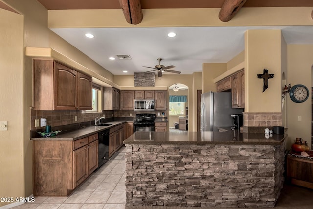 kitchen featuring ceiling fan, a peninsula, decorative backsplash, black appliances, and dark countertops