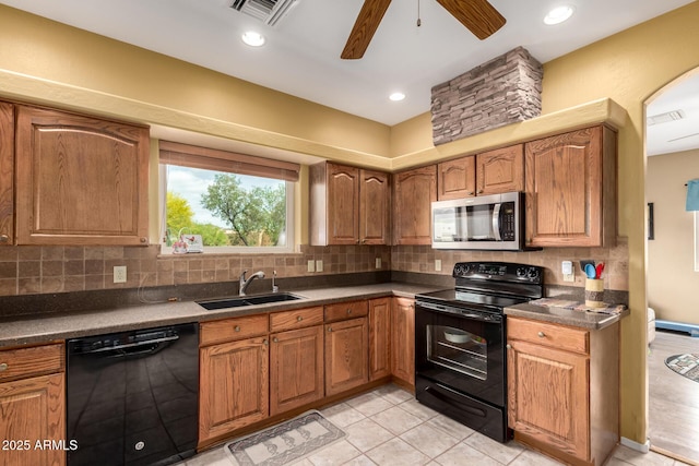 kitchen featuring backsplash, visible vents, black appliances, and a sink