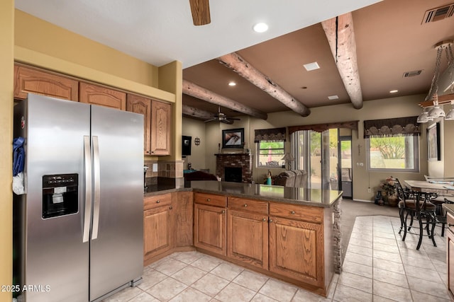 kitchen featuring open floor plan, stainless steel refrigerator with ice dispenser, a ceiling fan, and visible vents