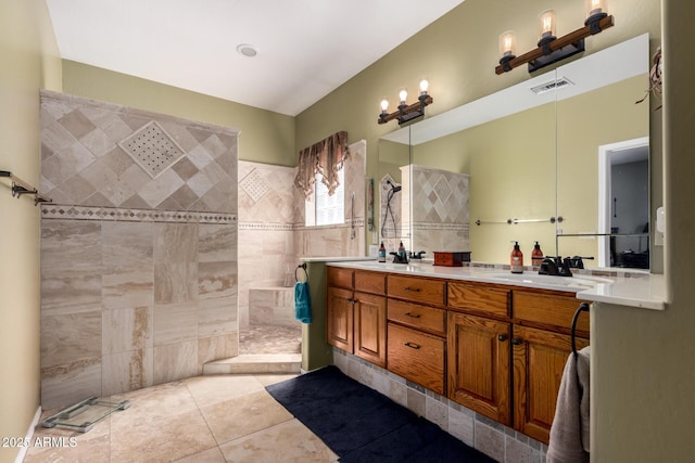 bathroom featuring visible vents, a sink, a walk in shower, tile patterned flooring, and double vanity