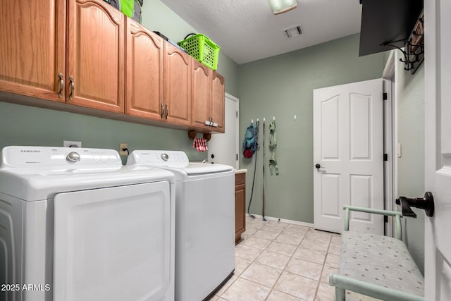 laundry area with cabinet space, light tile patterned floors, visible vents, and washer and dryer