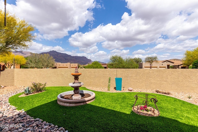 view of yard featuring a mountain view and a fenced backyard
