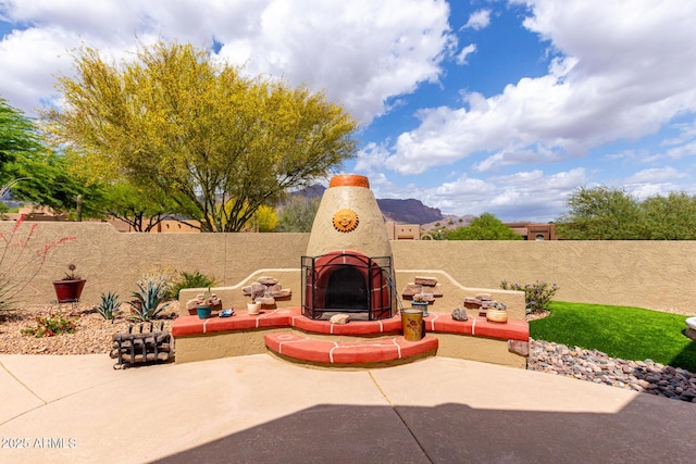 view of patio / terrace featuring exterior fireplace and a fenced backyard