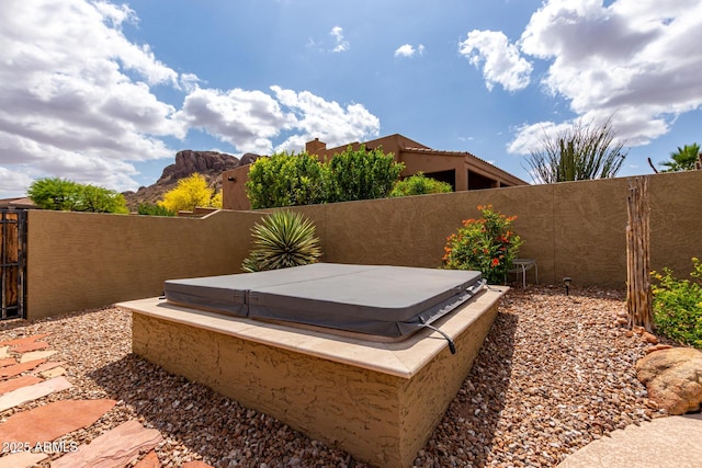 view of yard featuring a covered hot tub and fence