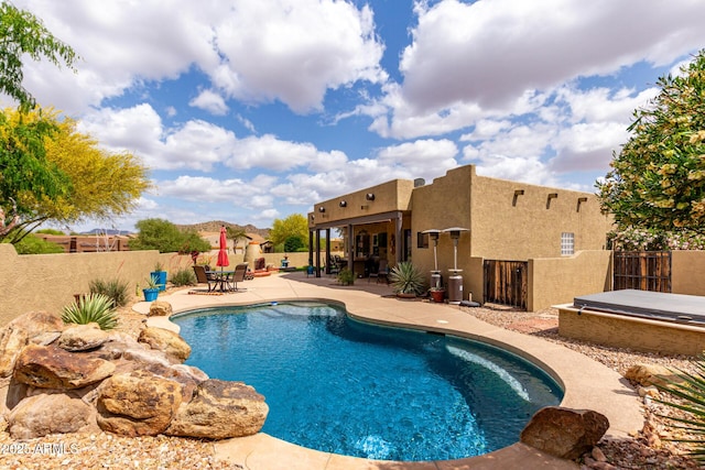 view of pool featuring a patio area, a hot tub, a fenced in pool, and a fenced backyard