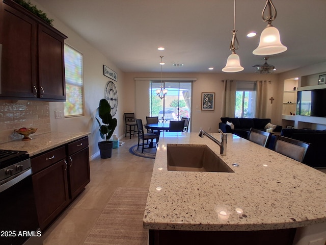 26947 W Adam Ave, Buckeye, AZ 85396 - kitchen featuring a sink, range with gas stovetop, a center island with sink, pendant lighting, and recessed lighting