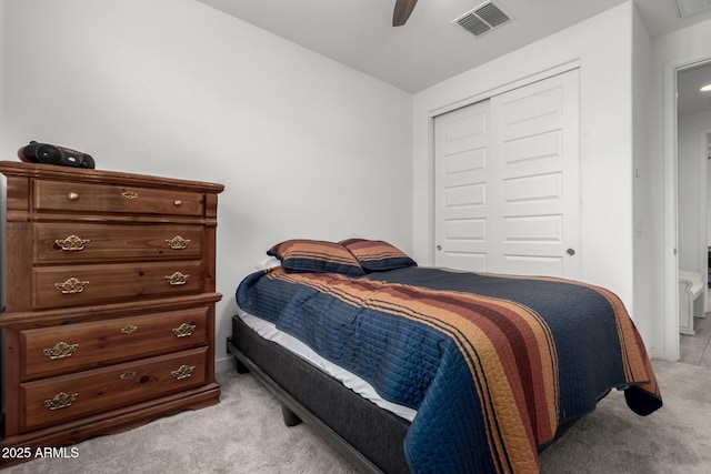 carpeted bedroom with a closet, lofted ceiling, and ceiling fan