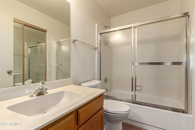 5808 E Brown Rd Unit 119, Mesa, AZ 85205 - bathroom featuring a textured wall, toilet, vanity, and enclosed tub / shower combo