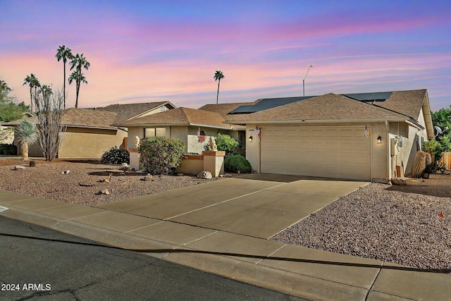 view of front of home with solar panels and a garage