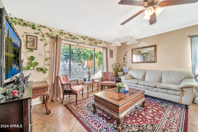 living room with ceiling fan, light tile patterned flooring, and a textured ceiling