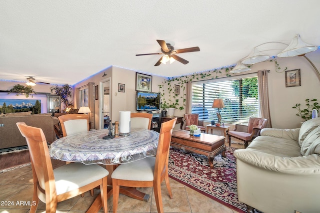 tiled dining room with a textured ceiling and ceiling fan