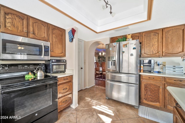 kitchen featuring a raised ceiling, light tile patterned floors, and stainless steel appliances