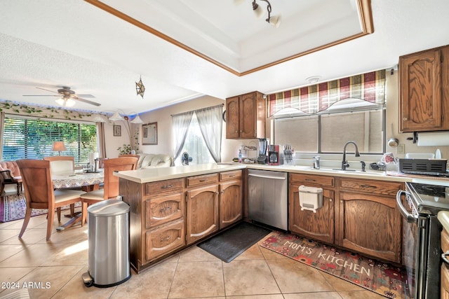 kitchen with kitchen peninsula, ceiling fan, a healthy amount of sunlight, and appliances with stainless steel finishes