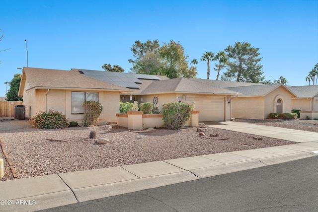 ranch-style home featuring solar panels, a garage, and central air condition unit