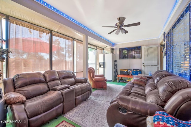 living room featuring ceiling fan, crown molding, and light carpet