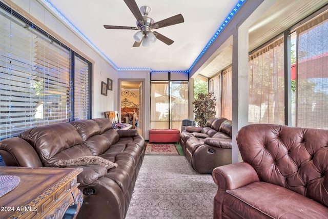 living room featuring ceiling fan, a healthy amount of sunlight, and crown molding