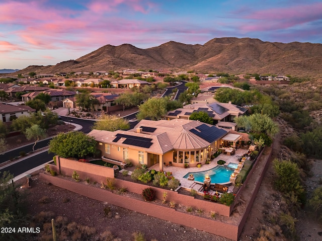 aerial view at dusk featuring a mountain view