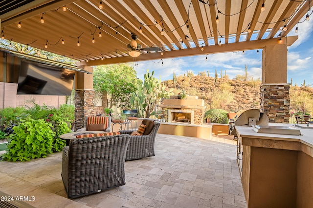 view of patio with an outdoor fireplace and area for grilling