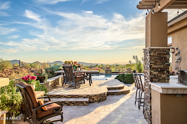 view of patio with an outdoor bar and a mountain view