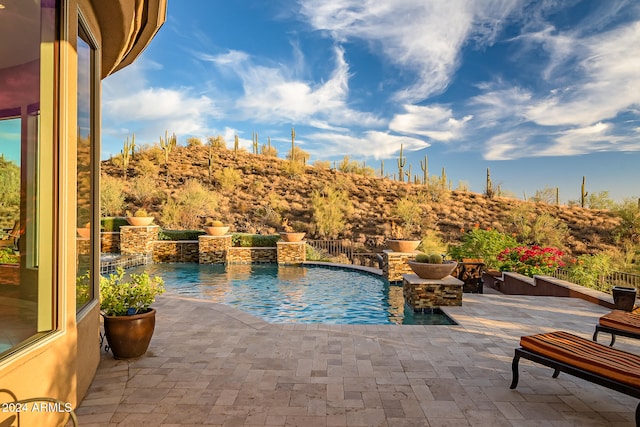 view of pool with a patio and pool water feature