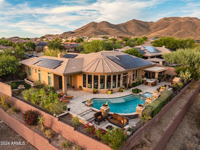 exterior space with a patio, a mountain view, a hot tub, and an outdoor hangout area