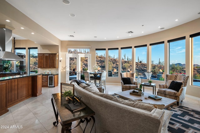 living room featuring wine cooler, french doors, light tile patterned flooring, and a mountain view