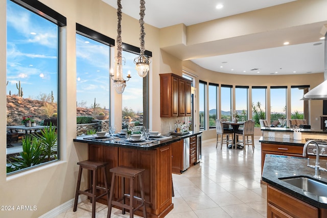 kitchen featuring a breakfast bar area, sink, a kitchen island with sink, and plenty of natural light