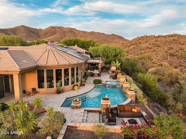 view of pool with a patio, an outdoor living space, and a mountain view